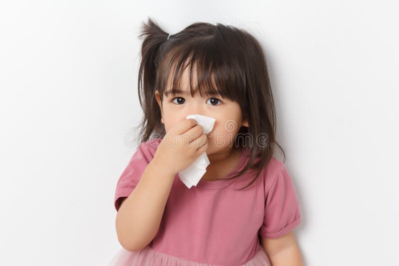 Ragazzina asiatica che tiene in mano un tessuto e si soffia il naso. bambino con rinite fredda. virus e infezione. sintomo coronav
