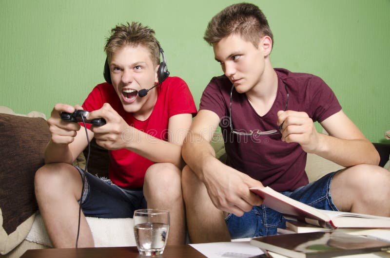 Young boy distracting his brother studying by yelling and playing games. Age difference. Young boy distracting his brother studying by yelling and playing games. Age difference