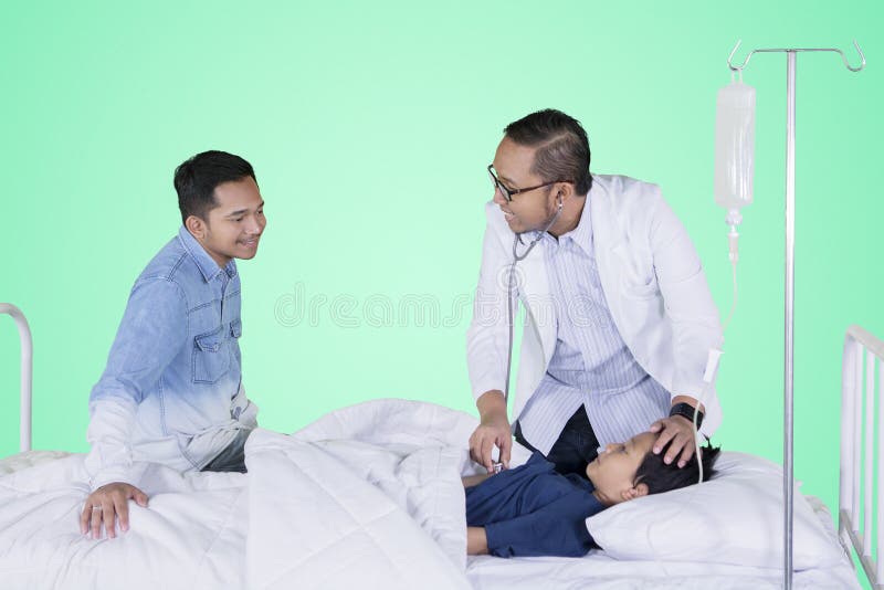 Ragazzino che esamina dal suo medico nello studio immagine stock Ragazzino che esamina dal suo medico nello studio immagine stock