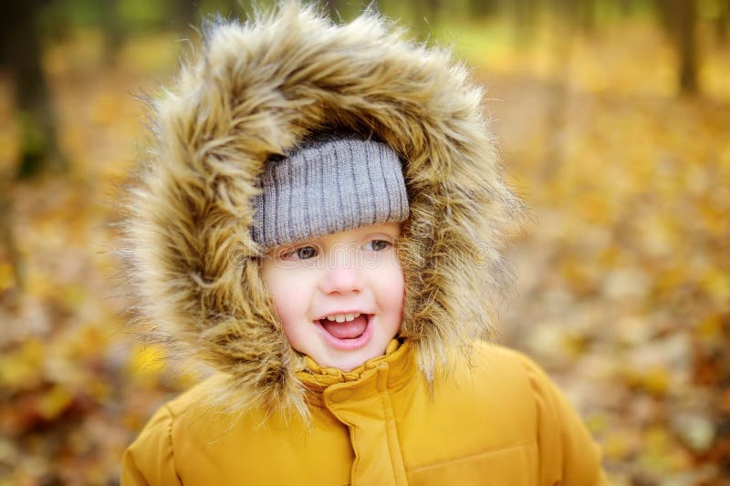 Ragazzino durante la passeggiata nella foresta al giorno soleggiato freddo di autunno immagine stock Ragazzino durante la passeggiata nella foresta al giorno soleggiato freddo di autunno immagine stock
