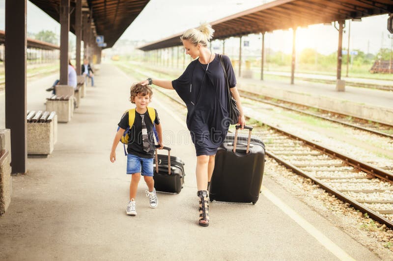 Ragazzino e madre svegli su una stazione ferroviaria fotografia stock libera da diritti Ragazzino e madre svegli su una stazione ferroviaria fotografia stock libera da diritti