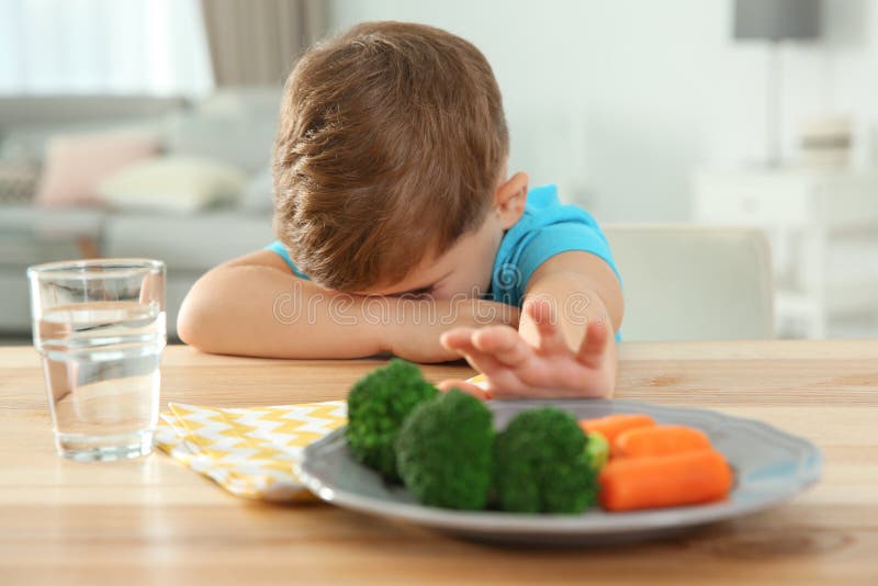 Ragazzino infelice che rifiuta di mangiare le verdure alla tavola