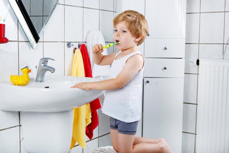 Ragazzo adorabile del bambino che pulisce i suoi denti, all'interno immagini stock Ragazzo adorabile del bambino che pulisce i suoi denti, all'interno immagini stock