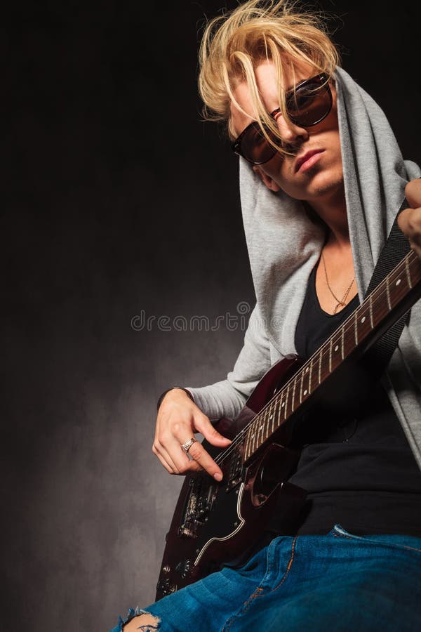 Ragazzo biondo che gioca chitarra elettrica in studio fotografie stock libere da diritti Ragazzo biondo che gioca chitarra elettrica in studio fotografie stock libere da diritti