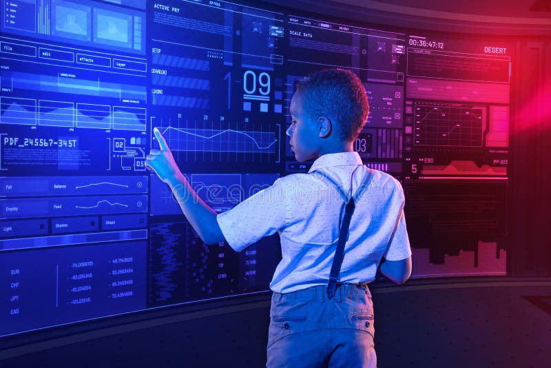 Ragazzo calmo che tocca lo schermo mentre controllando le informazioni fotografie stock Ragazzo calmo che tocca lo schermo mentre controllando le informazioni fotografie stock