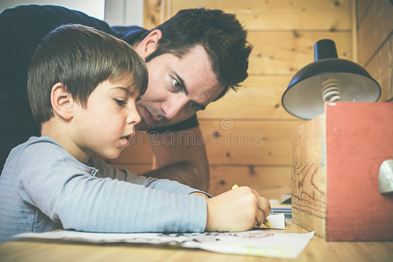 Ragazzo che assorbe la stanza con suo padre Bambino che dipinge un'immagine fotografia stock