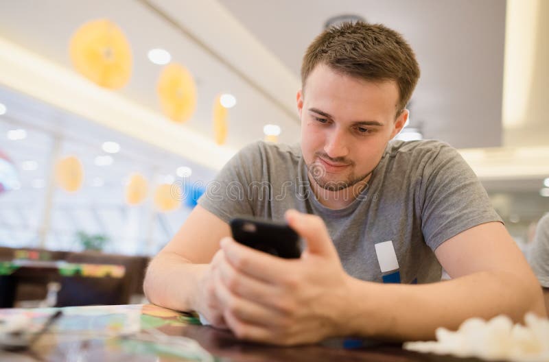 Ragazzo che controlla il suo telefono immagini stock libere da diritti Ragazzo che controlla il suo telefono immagini stock libere da diritti