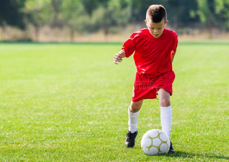Ragazzo che calcia un pallone da calcio fotografie stock