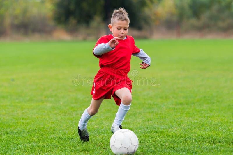 Ragazzo che calcia un pallone da calcio immagine stock libera da diritti