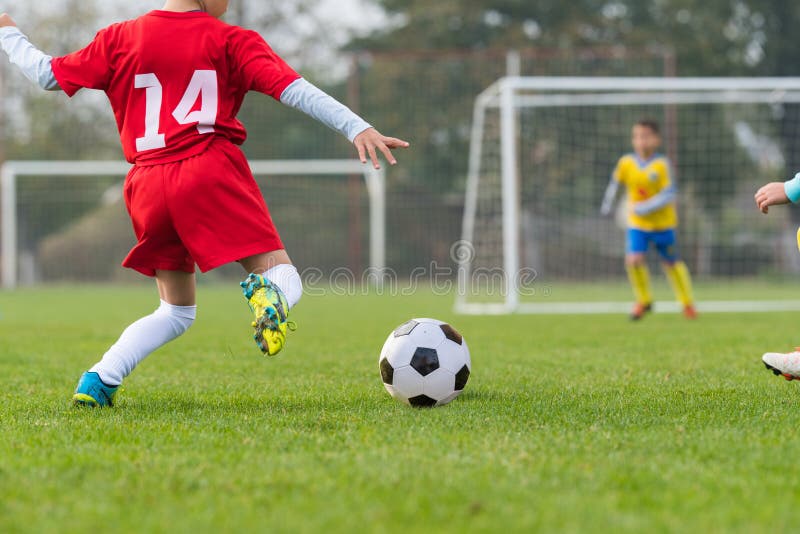 Ragazzo che calcia un pallone da calcio fotografie stock libere da diritti