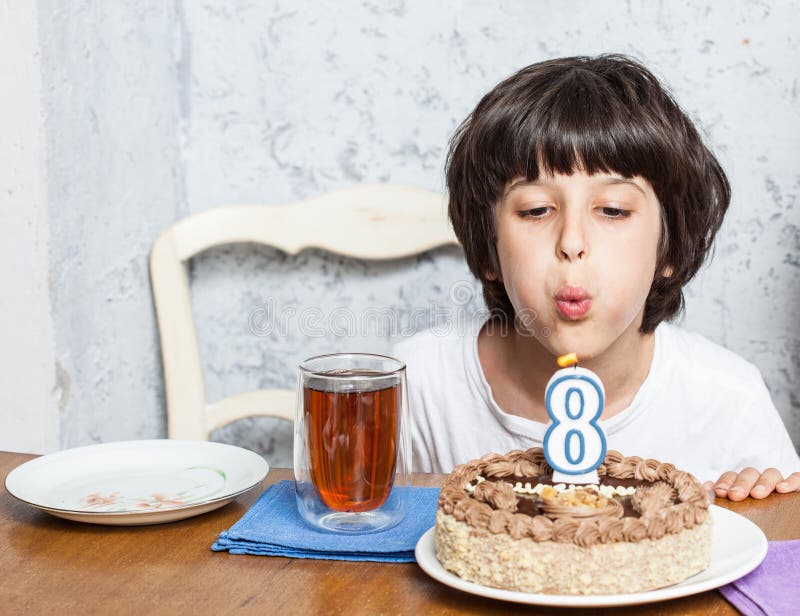 Ragazzo che spegne le candele sulla torta di compleanno fotografia stock libera da diritti Ragazzo che spegne le candele sulla torta di compleanno fotografia stock libera da diritti