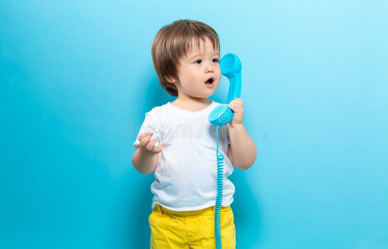 Ragazzo del bambino con un telefono antiquato immagine stock libera da diritti Ragazzo del bambino con un telefono antiquato immagine stock libera da diritti