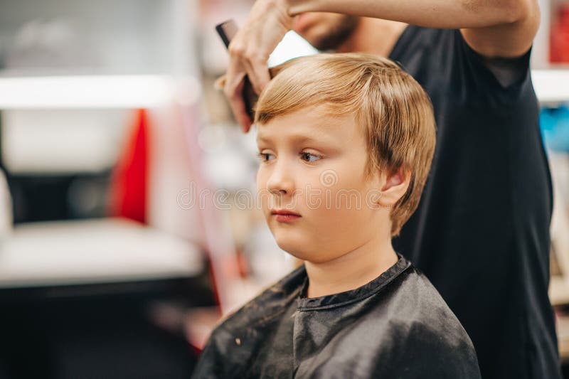 Ragazzo del ragazzino che ottiene nuovo taglio di capelli fotografie stock libere da diritti Ragazzo del ragazzino che ottiene nuovo taglio di capelli fotografie stock libere da diritti