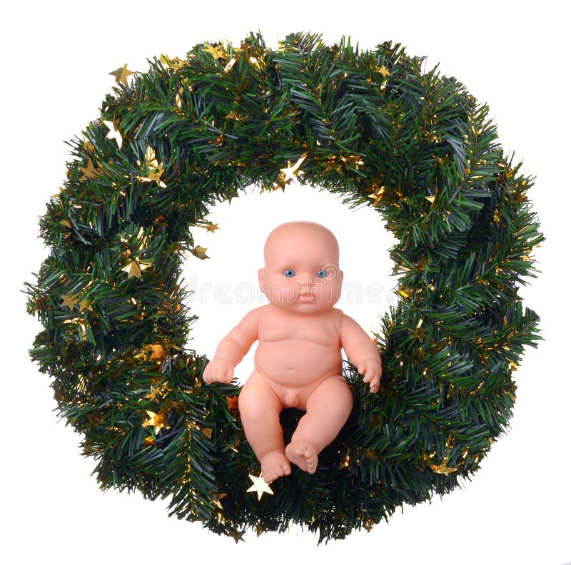 Ragazzo di angelo della bamboletta che si siede sulla corona di natale fotografia stock Ragazzo di angelo della bamboletta che si siede sulla corona di natale fotografia stock