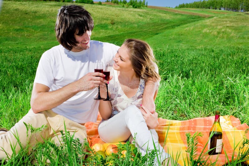 Ragazzo e ragazza piacevole con i bicchieri di vino immagine stock