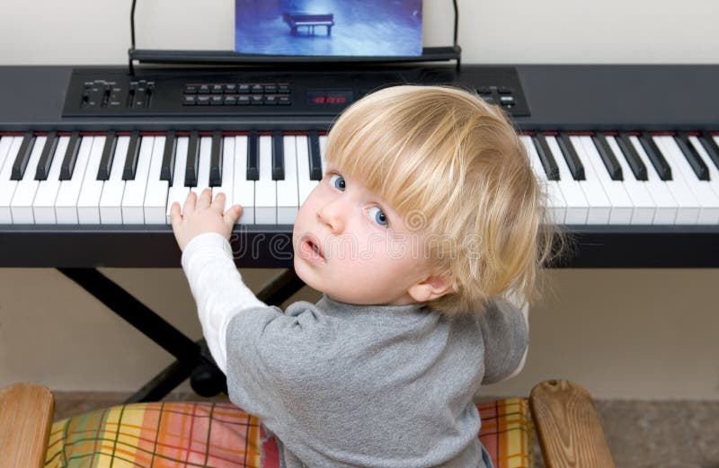 Ragazzo giovane che gioca piano o tastiera fotografie stock