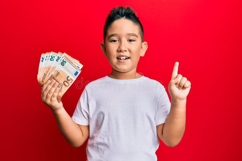 Ragazzo ispanico con un pugno di banconote da 50 euro sorridente con un'idea o una domanda che punta il dito con la faccia felice numero uno