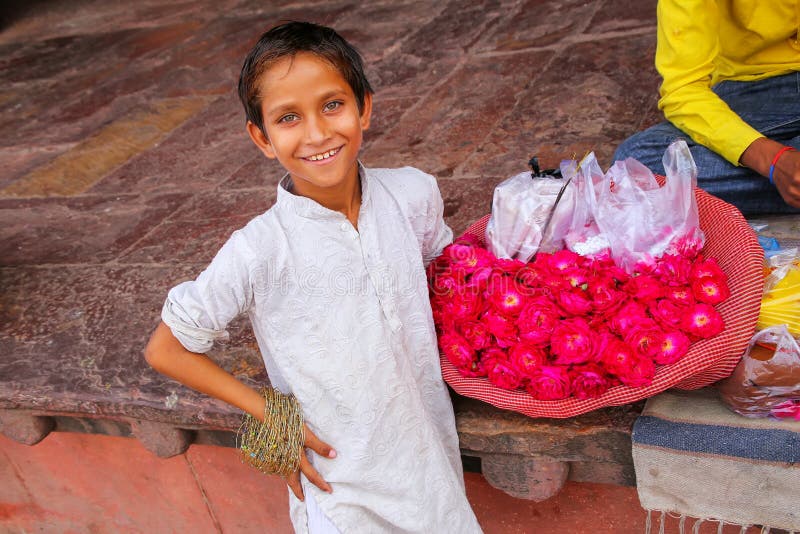Ragazzo locale che vende i fiori nel cortile di Jama Masjid in grasso fotografie stock libere da diritti Ragazzo locale che vende i fiori nel cortile di Jama Masjid in grasso fotografie stock libere da diritti