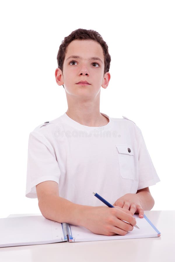 Ragazzo sveglio sullo scrittorio che studia e che pensa immagine stock Ragazzo sveglio sullo scrittorio che studia e che pensa immagine stock