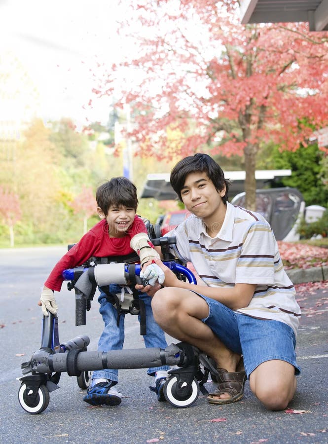 Ragazzo teenager con il piccolo fratello invalido in camminatore