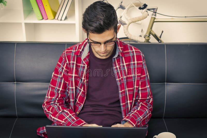 Ragazzo teenager serio che scrive sul computer portatile immagine stock libera da diritti Ragazzo teenager serio che scrive sul computer portatile immagine stock libera da diritti