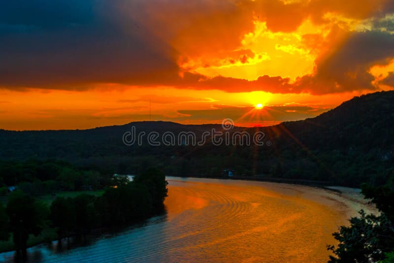 Amazing Austin Sunset light beams and Sun Rays Star Burst. over Austin lake , colorado river bend , or Travis lake is the most amazing sunset over Austin , Texas that is so colorful , red and orange , and yellow with amazing sun burst or star burst as the sun sets behind the horizon with hills of the central texas hill country. Amazing Austin Sunset light beams and Sun Rays Star Burst. over Austin lake , colorado river bend , or Travis lake is the most amazing sunset over Austin , Texas that is so colorful , red and orange , and yellow with amazing sun burst or star burst as the sun sets behind the horizon with hills of the central texas hill country.