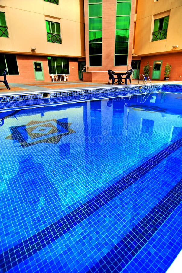 A colorful view of a bright blue swimming pool at a hotel in Bahrain. A colorful view of a bright blue swimming pool at a hotel in Bahrain.