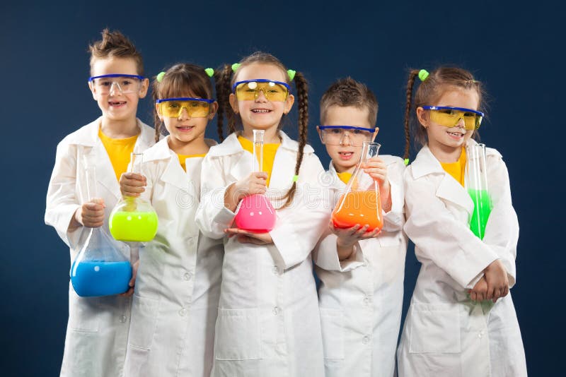 Raggruppi i bambini felici che fanno gli esperimenti di scienza in laboratorio
