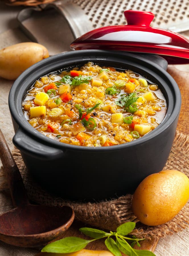 Delicious lentil and vegetable stew in a rustic kitchen in an open crock, high angle view. Delicious lentil and vegetable stew in a rustic kitchen in an open crock, high angle view