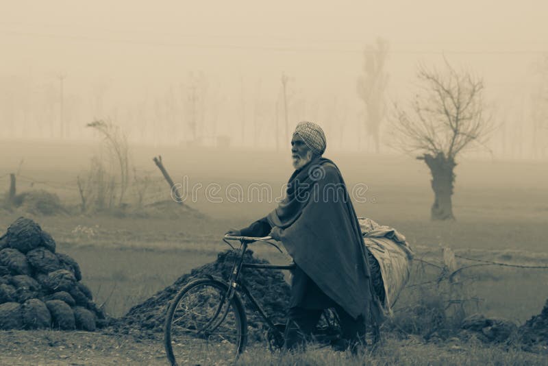 Raikot Punjab India 01 09 2021 A farmer on cycle in the foggy winter morning agricultural field