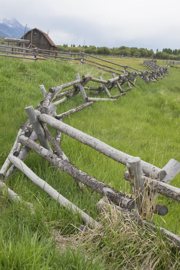 A rail fence leads into an old historic barn.