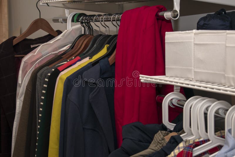 Rail with Multicolored Clothes on Hangers and in Containers. Open