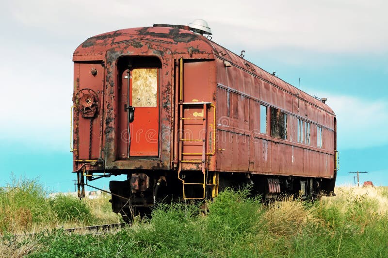 Rusted and worn out, an old passenger railcar sits on a rail siding. Rusted and worn out, an old passenger railcar sits on a rail siding.