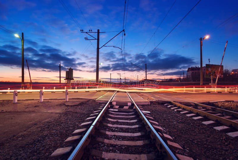 Railroad crossing with car lights in motion at night royalty free stock photo Railroad crossing with car lights in motion at night royalty free stock photo
