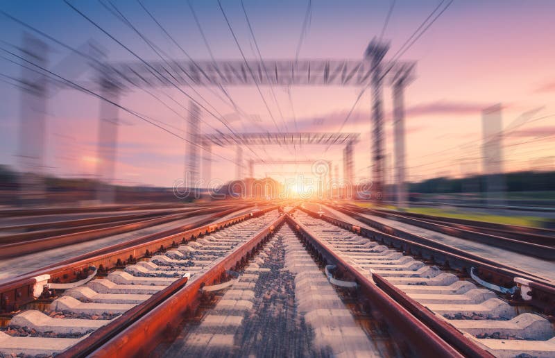 Railroad and pink sky with motion blur effect at sunset