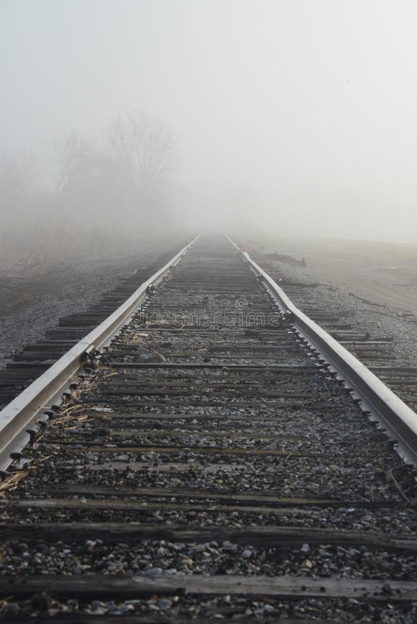 Railroad tracks fading into the misty morning light.