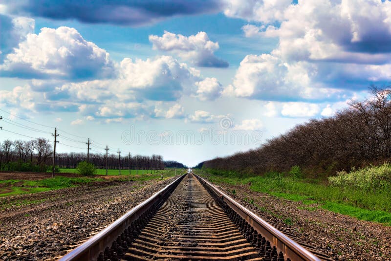 Railroad Tracks Going into the Distance among the Spring Fields Stock