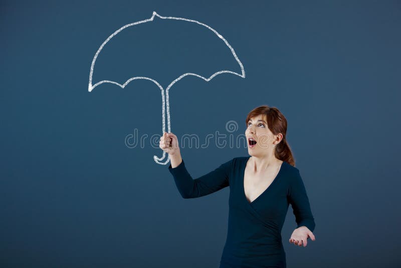 Young woman holding a umbrella drawn with chalk on the wall. Young woman holding a umbrella drawn with chalk on the wall