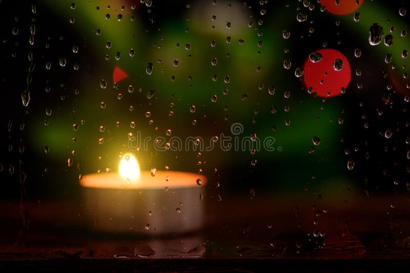 Rain Drop On Mirror With Blurred Image Of Candle Light. Stock Photo