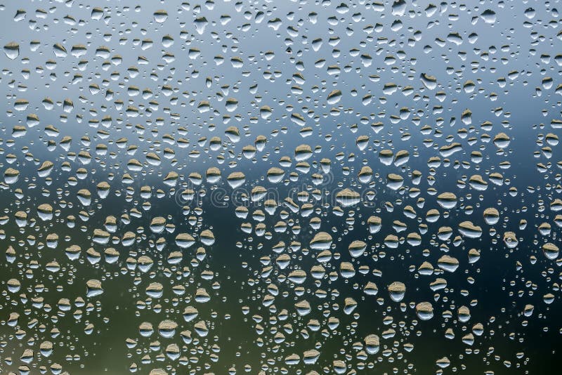 Rain Drops on Window Glasses Surface with Cloudy Background . Natural