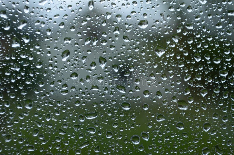 Rain Drops on Window Glasses Surface with Cloudy Background . Natural