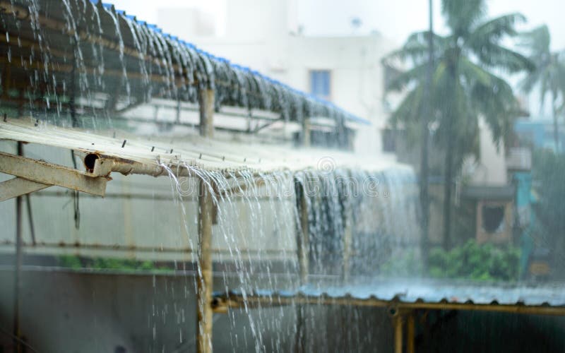Rain on a Tin Roof. Rain Falling from the Roof. Rainy day nature background. Selective Focus on Foreground royalty free stock photos