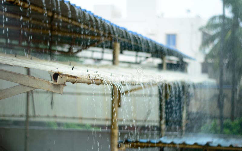 Rain on a Tin Roof. Rain Falling from the Roof. Rainy day nature background. Selective Focus on Foreground royalty free stock photography