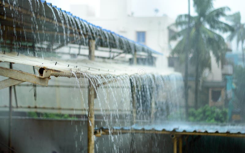 Rain on a Tin Roof. Rain Falling from the Roof. Rainy day nature background. Selective Focus on Foreground stock image