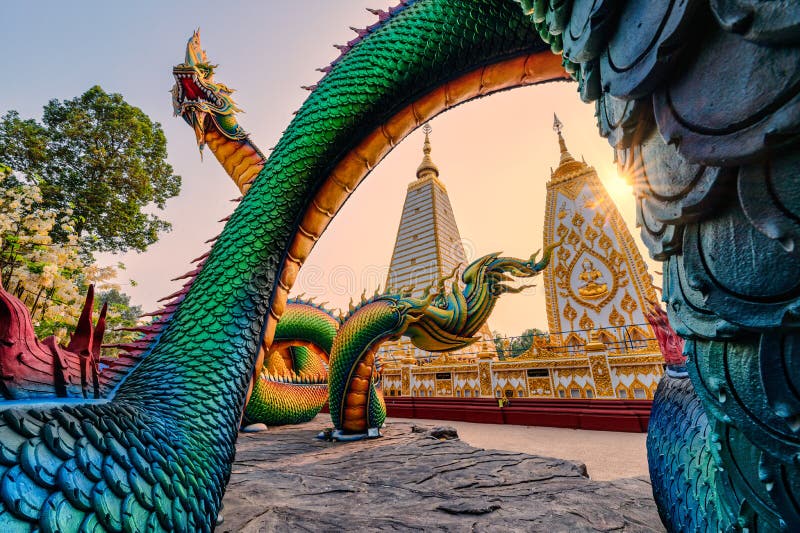 Rainbow carve serpent or colorful Thai Naga surrounding Sri Maha Pho Chedi stupa in the sunset at Wat Phra That Nong Bua stock photography
