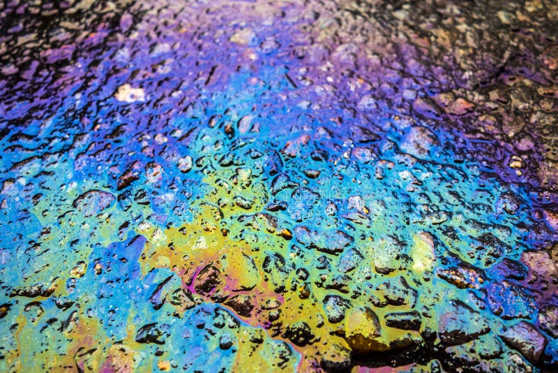 Rainbow Liquid Petrol Pollution Leak on Asphalt Road Stock Image