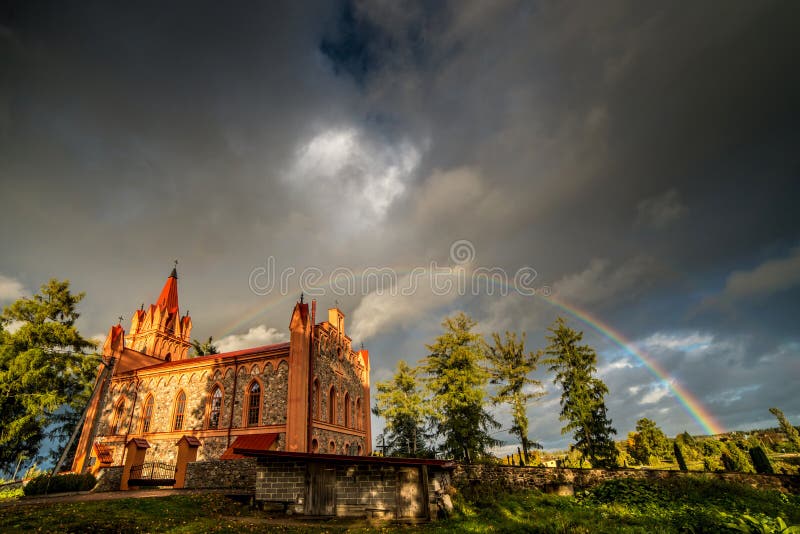 Rainbow over the church, dramatic stormy clouds