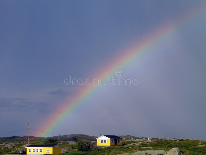 Rain has cleared for the moment and a large rainbow appears ove the brightly coloured homes of Peggy's Cove, Nova Scotia. Rain has cleared for the moment and a large rainbow appears ove the brightly coloured homes of Peggy's Cove, Nova Scotia