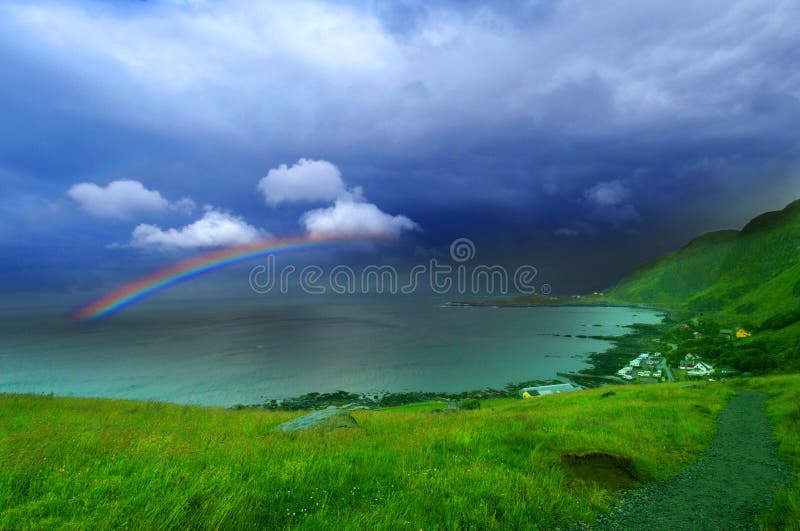 The view of a beautiful rainbow over the sea from the Runde Island in Norway. The view of a beautiful rainbow over the sea from the Runde Island in Norway.