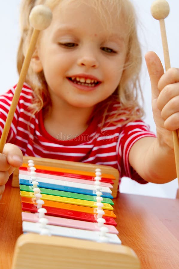 Bambina indossa a strisce t-shirt rossa di gioco arcobaleno xilofono.